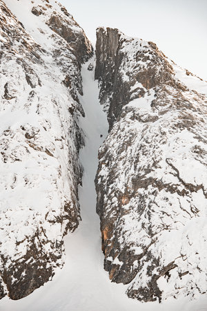 The two skiers had already reached the middle of the steep mountain descentの写真素材