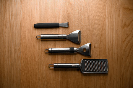Various kitchen tools: a grater, a vegetable peeler and a paring knifeの写真素材