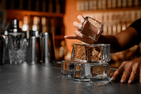 Female hands building a pyramid of ice cubes on a bar counterの写真素材
