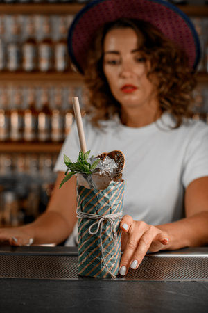 Focus on a tall cocktail wrapped in gift paper and tied with white threadの写真素材