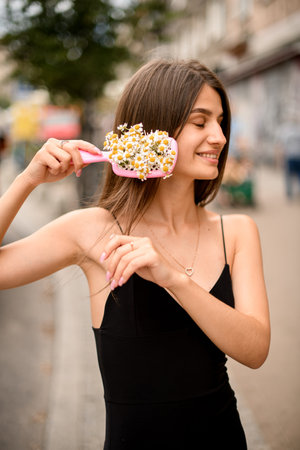happy girl with hair comb and vibrant flower interweavingの写真素材