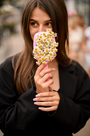 White flowers in hands of a girl with brown straight hair on a blurred backgroundの写真素材