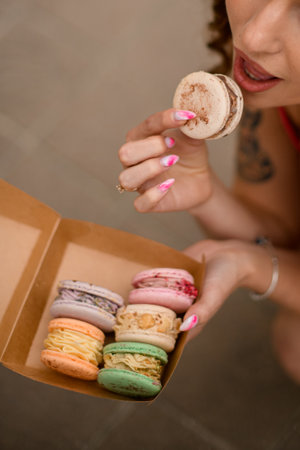 Cardboard box with delightful macarons in a hands of the young womanの写真素材
