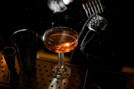 Bartender breaking ice cube with ice pick while holding ice with black towelの写真素材