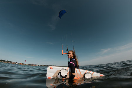 Long-haired girl with surfboard in the waterの写真素材