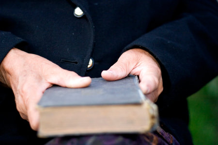  Senior's hands on old bookの写真素材