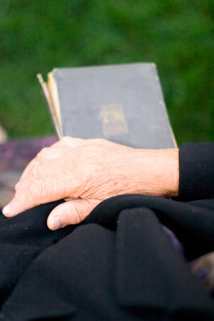  Senior's hands on old bookの写真素材