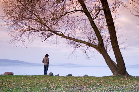 A young woman / lady is sitting and have a relax under a treeの写真素材