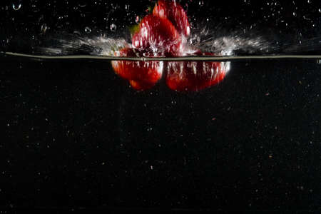 splashing strawberry into a waterの写真素材