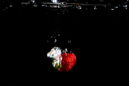 splashing strawberry into a water