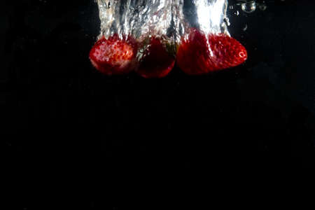 splashing strawberry into a waterの写真素材