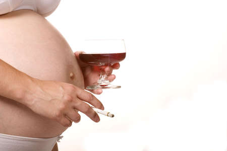 A pregnant woman with wine and cigaretteの写真素材