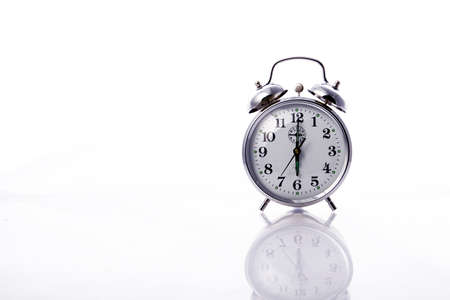 Vintage dusty alarm clock against a white backgroundの写真素材