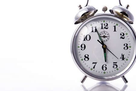 Vintage dusty alarm clock against a white backgroundの写真素材