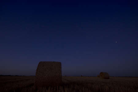 End of day over field with hay baleの写真素材