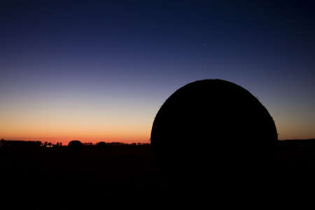 End of day over field with hay baleの写真素材