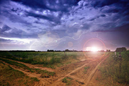 Rural road and dark storm cloudsの写真素材