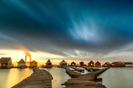 Sunset lake Bokod with pier and fishing wooden cottages, power plant in background, Hungaryの写真素材