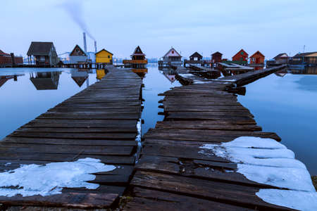 Sunset lake Bokod with pier and fishing wooden cottages, power plant in background, Hungaryの写真素材