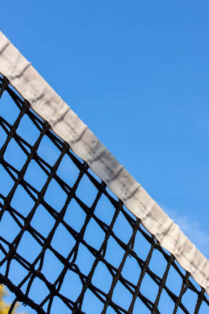 Tennis court net and blue sky in the backgroundの写真素材