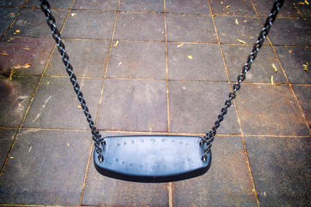 Empty chain swing in playground in cityの写真素材