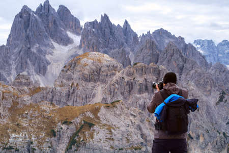 Photographer taking a picture the sunset over the Dolomites Alps-Italyの写真素材