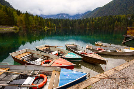 Alpine landscape and colorful boats near Slovenian-Italy border, Lake Fusine,Italyの写真素材