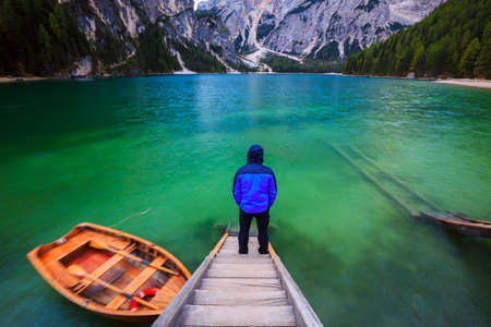 Man alone at the Braies Lake ( Pragser Wildsee ) in Dolomites mountains, Sudtirol, Italyの写真素材