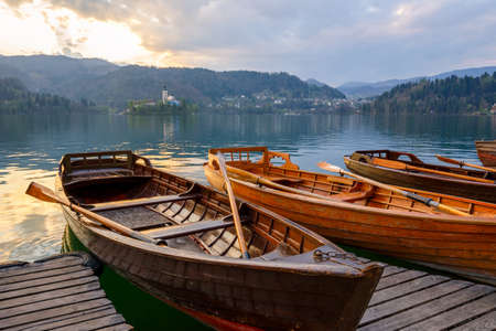 Traditional wooden boats Pletna on the backgorund of Church on the Island on Lake Bled, Slovenia.  Europe.の写真素材