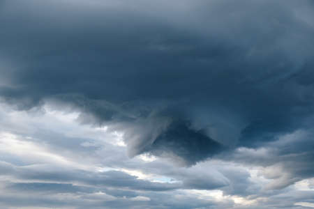 Dramatic dark cloudy sky over mountain, natural photo backgroundの写真素材