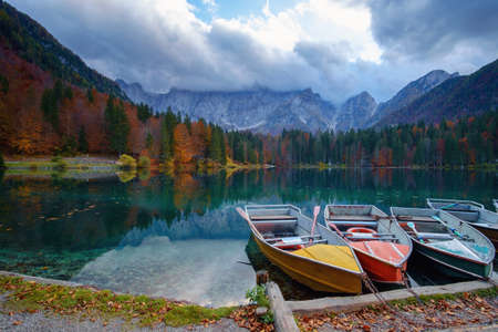 Alpine lake and colorful boats near Slovenian-Italy border, Lake Fusine,Italyの写真素材