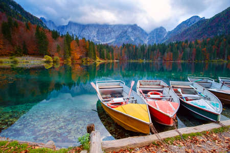 Alpine lake and colorful boats near Slovenian-Italy border, Lake Fusine,Italyの写真素材