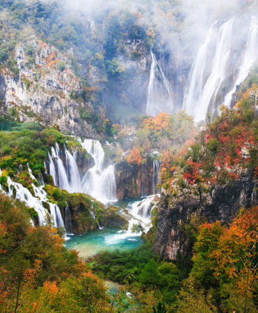 Picturesque autumn waterfall in a calm forest environment in rainy, foggy autumn weather in Plitvice lakesの写真素材