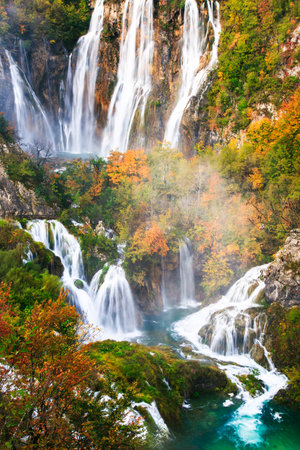Picturesque autumn waterfall in a calm forest environment in rainy, foggy autumn weather in Plitvice lakesの写真素材