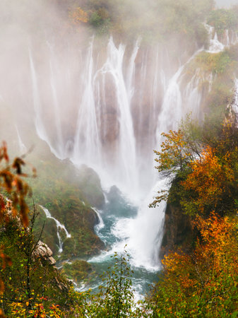 Picturesque autumn waterfall in a calm forest environment in rainy, foggy autumn weather in Plitvice lakesの写真素材