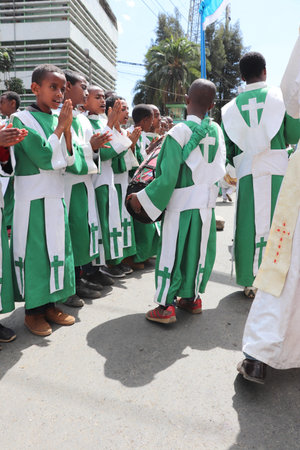 Young girls and boys dressed in colourful traditional clothing sing and chant while accompanying the...