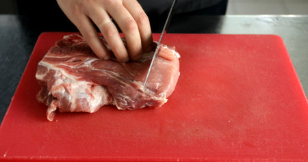 The chef cuts raw meat with the knife. A restaurant.の写真素材