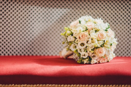 Wedding bouquet of roses lying on a red velvetの写真素材