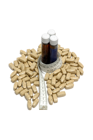 Bottles of L-Carnitine, Guarana or Amino Acids, surrounded with tablets of fat burner and tape-line. Fitness Line.の写真素材