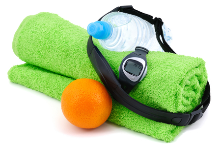Heart rate monitor, bottle of water, orange and towel. Isolated on whiteの写真素材