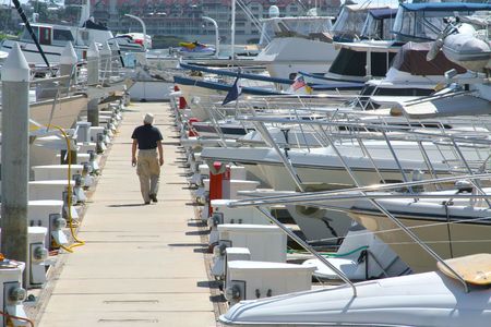 A man taking a walk out to his boat while admiring the others.の写真素材