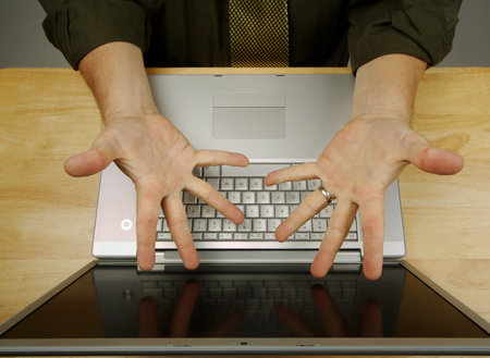 Frustrated businessman shows his frustration while working on his laptop.