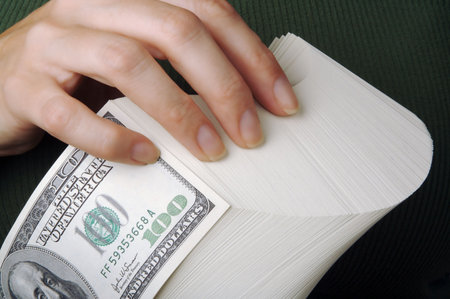 Woman holds a stack of one hundred dollar bills.