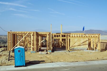 Construction site with new home framing and outhouse.の写真素材