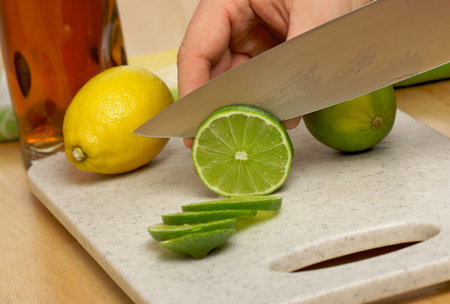 Slicing a lime on a cutting board.の写真素材