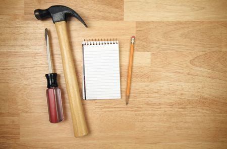 Pad of Paper, Pencil, Hammer and Screwdriver on a Wood Background.の写真素材