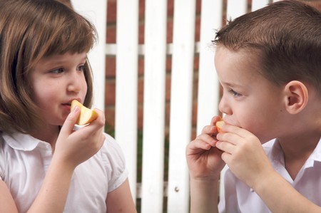Sister and Brother Having Fun Eating an Appleの写真素材