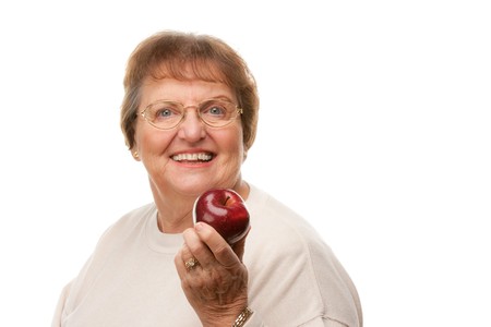 Attractive Senior Woman with Apple Isolated on a White Background.の写真素材