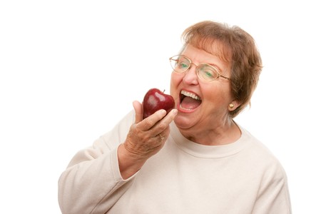 Attractive Senior Woman with Apple Isolated on a White Background.の写真素材