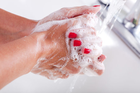 Woman Washing Hands in the Kitchen Sink.